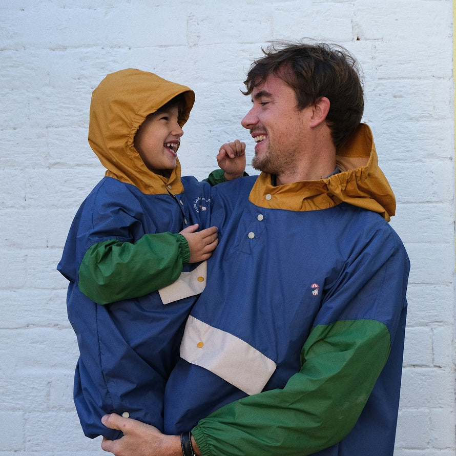 Poncho de pluie Poule Party ash Blue avec un père et son enfant